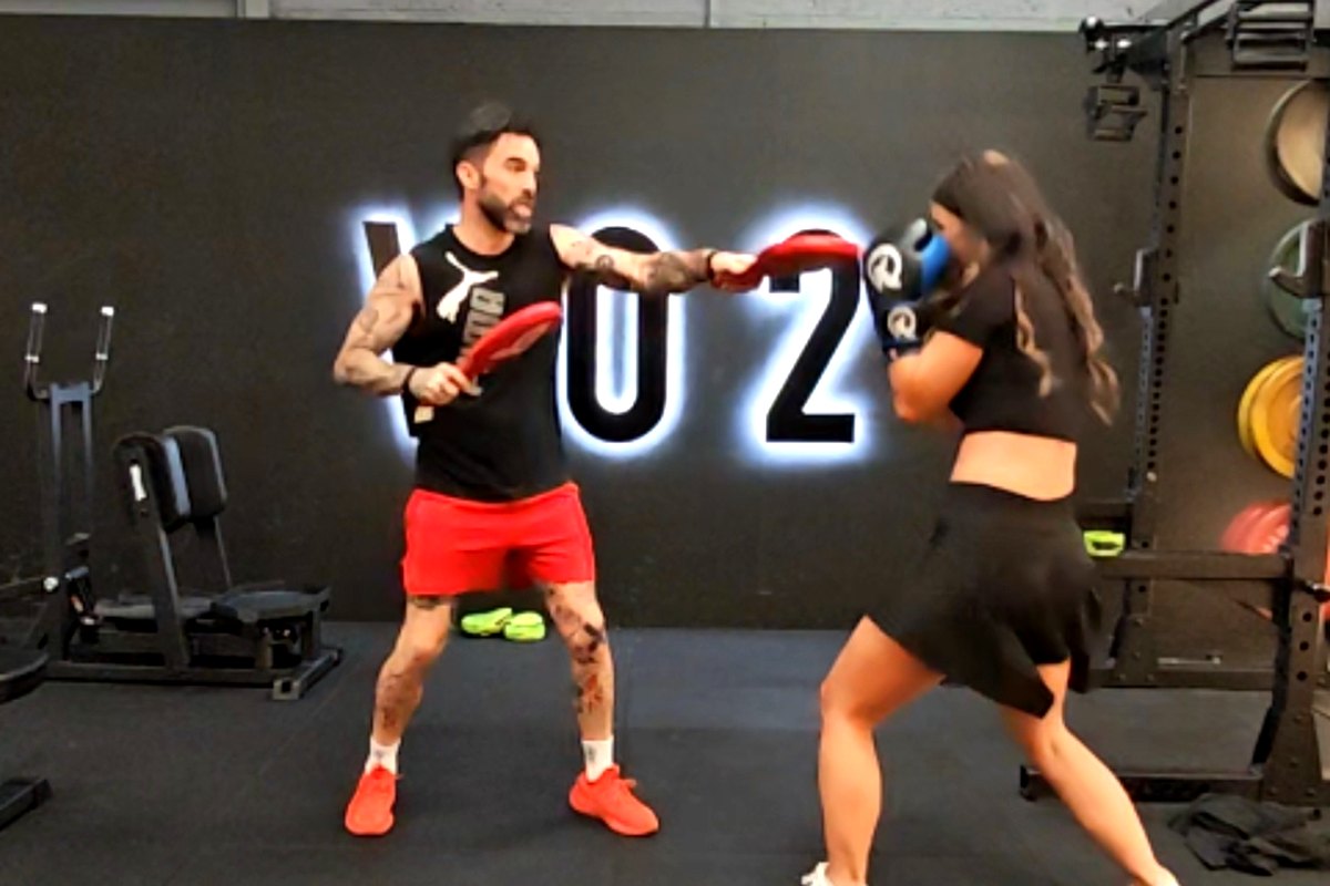 Ian Wilson holding boxing pads while a client works through a combination at Vo2 in Portadown